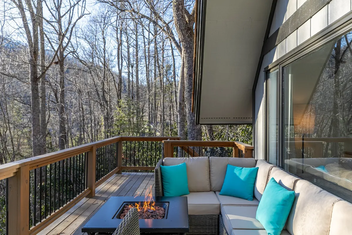An inviting outdoor area with a cozy fire pit, surrounded by comfortable chairs and tall trees, creating a tranquil space for evening relaxation and deep conversation under the stars.