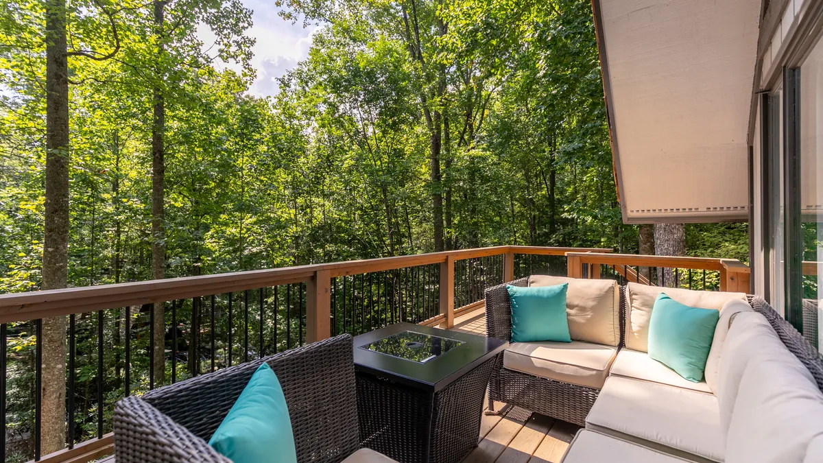 A serene outdoor seating area surrounded by lush greenery, featuring comfortable chairs and an outdoor table, perfect for enjoying nature or a quiet cup of coffee in the fresh mountain air.